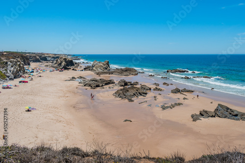 Sand with rocks at low tide at Samoqueira beach, Porto Côvo PORTUGAL photo