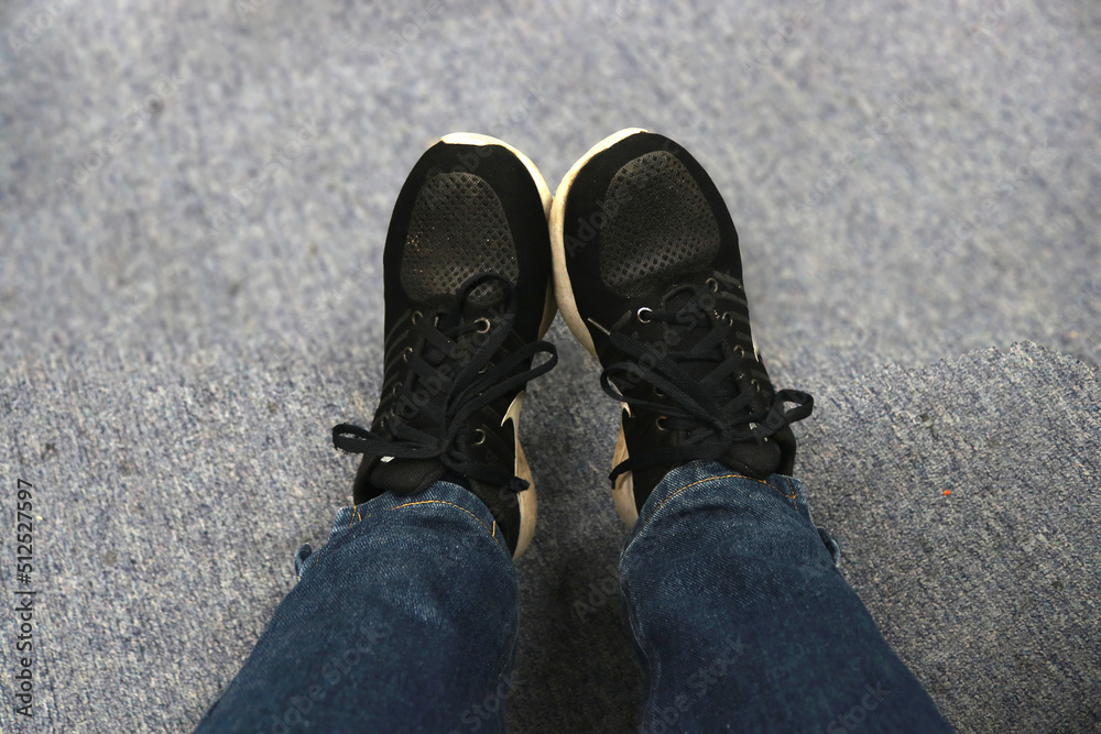 Photo of someone wearing sport shoes or sneakers and wearing jeans and relaxing