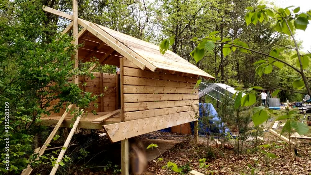 Chicken coop being build next to animal enclosure in back yard next to wooded area. Chicken coop being build next to animal enclosure in back yard next to wooded area.