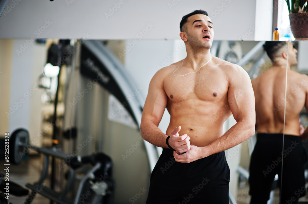 Muscular arab man training in modern gym. Fitness arabian men with naked torso doing exercises . Muscular arab man training in modern gym. Fitness arabian men with naked torso doing exercises .