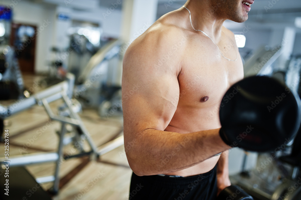 Muscular arab man training in with dumbbells modern gym. Fitness arabian men with naked torso doing workout . Muscular arab man training in with dumbbells modern gym. Fitness arabian men with naked torso doing workout .