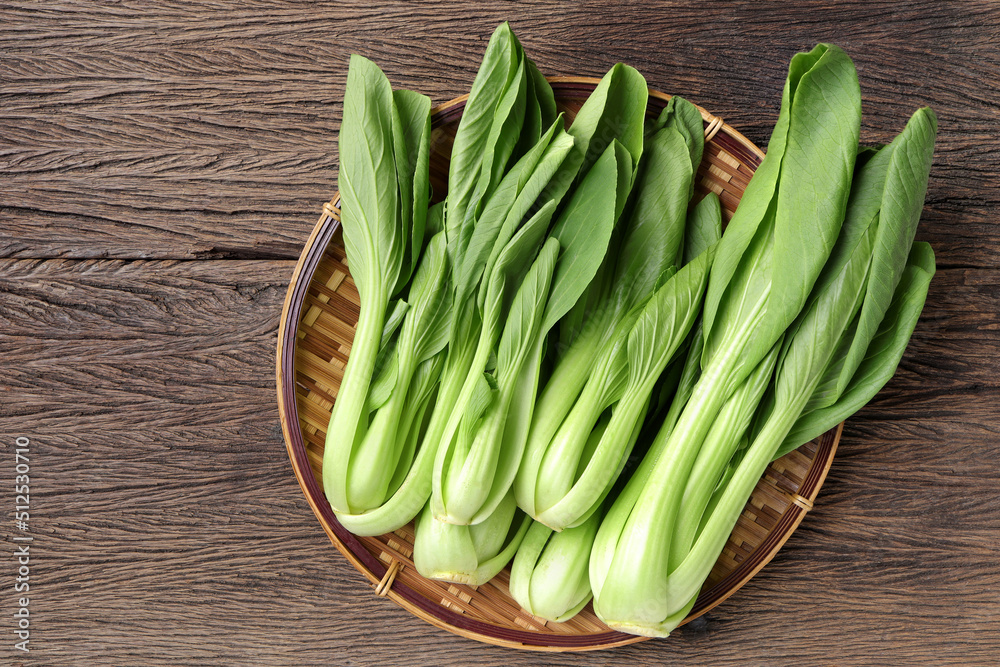 Close up of Bok choy or Chinese cabbage ,Cantonese vegetables on bamboo colander on the wooden background.Top view, copy space for text Close up of Bok choy or Chinese cabbage ,Cantonese vegetables on bamboo colander on the wooden background.Top view, copy space for text