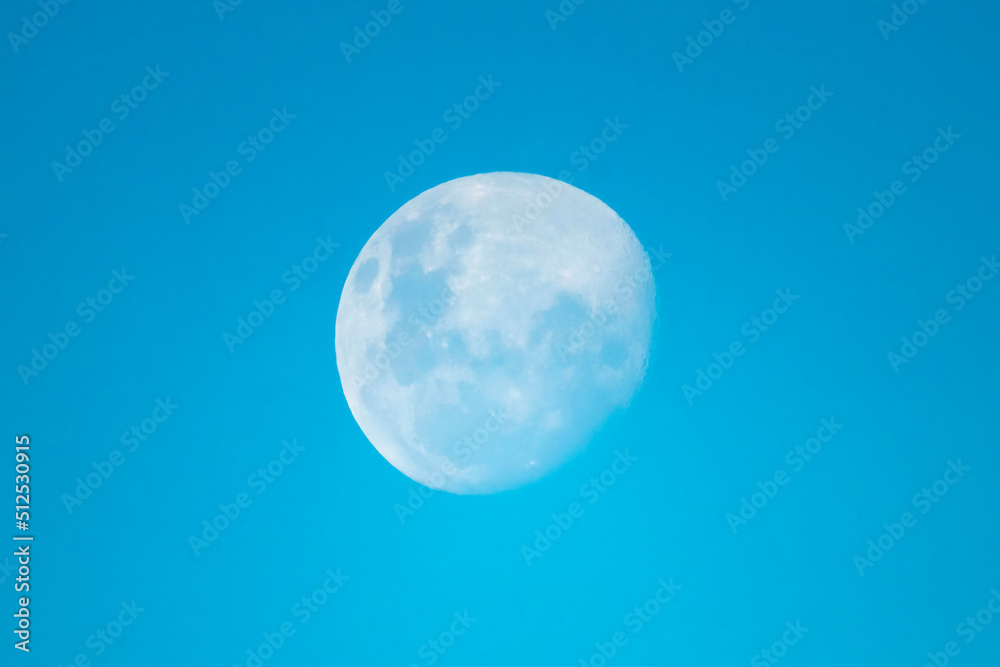 87 percent moon rising in the later afternoon blue sky 87 percent moon rising in the later afternoon blue sky