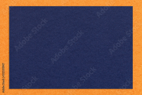 Photo Texture of craft navy blue color paper background with orange border, macro