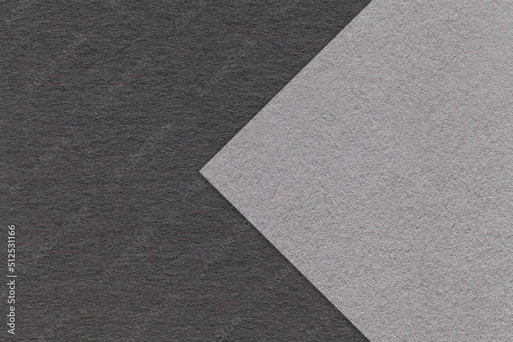 Fototapeta premium Texture of gray and black paper background, half two colors with arrow, macro. Structure of dense craft grey cardboard.