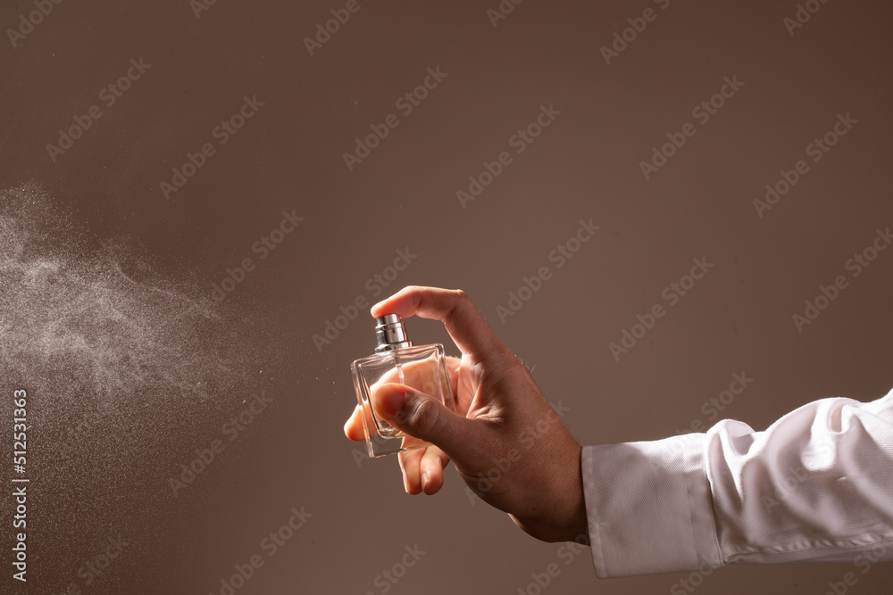 hand holding a spray can. Man perfume bottle. Aroma. background