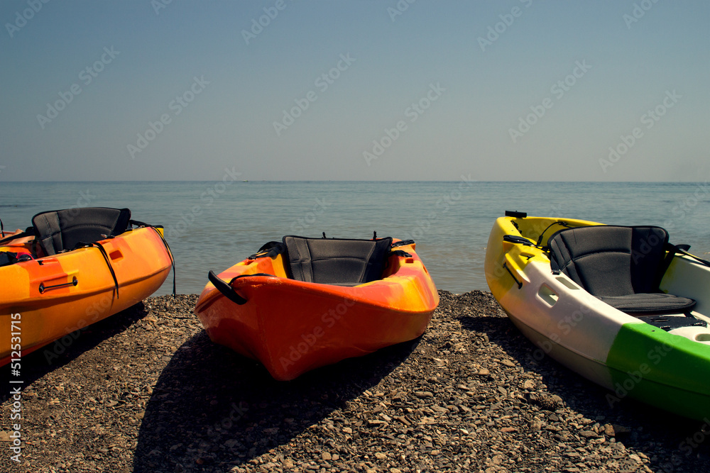 Kayak on the rocky shore of the sea, lake. Tourist tours rental on a boat with a paddle. Kayak on the rocky shore of the sea, lake. Tourist tours rental on a boat with a paddle.