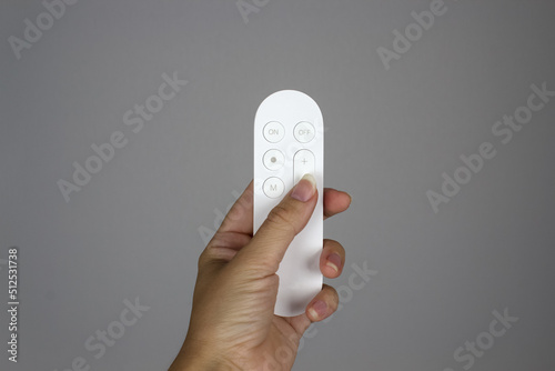 White control panel for appliances and household appliances in a hand. Finger presses a button