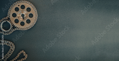 Gears from a car engine and a chain on a dark background. Poster, copy space
