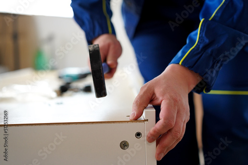 A man collects furniture. Hammer and nail