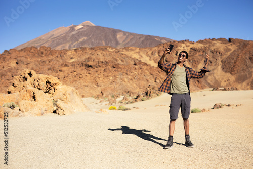 Young man taking selfie photo on a road trip. Man making memories on the mountain..