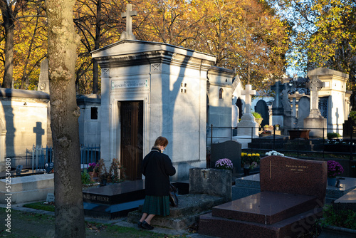 Obraz na plátně Woman kneeling and praying in Montparnasse cemetery (French : cimetiere du Montp