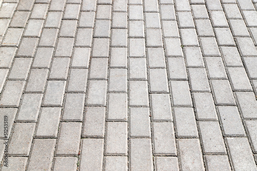 Sidewalk paved with gray tiles in perspective. Photo with selective focus