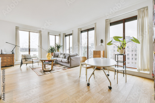 Modern furniture near windows in light apartment photo
