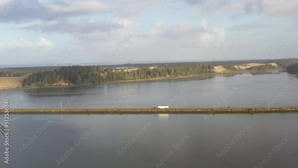 Truck crossing causeway in North Bend Oregon at high tide. Aerial view. Truck crossing causeway in North Bend Oregon at high tide. Aerial view.