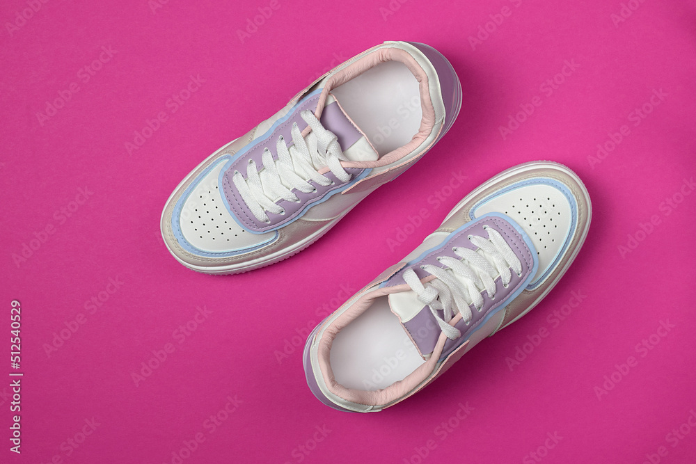 New white sneakers on a bright pink background. Trendy colorful photo in minimal style. Top view, flat lay. New white sneakers on a bright pink background. Trendy colorful photo in minimal style. Top view, flat lay.