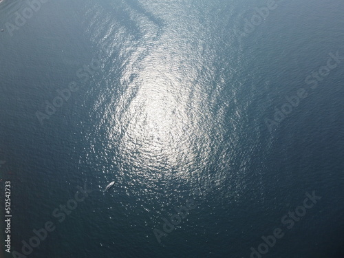 Aerial view from above on calm azure sea and volcanic rocky shores. Small waves on water surface in motion blur. Nature summer ocean sea beach background. Nobody. Holiday, vacation and travel concept