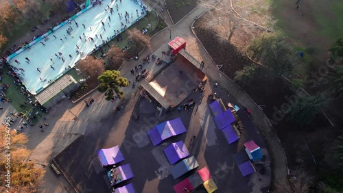 Aerial orbit of a skate park ramp with people skating on it, Parque Araucano, Santiago, Chile. photo