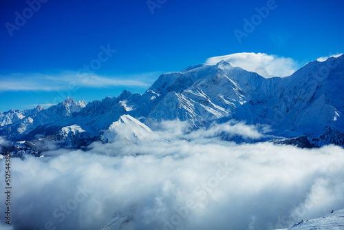 View above clouds in the mountains with high Alps peaks © Sergey Novikov