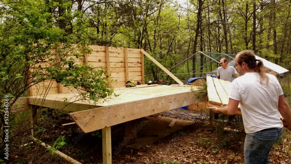 Man build partial wall of chicken house or coop using prebuild wood pallet. Man build partial wall of chicken house or coop using prebuild wood pallet.