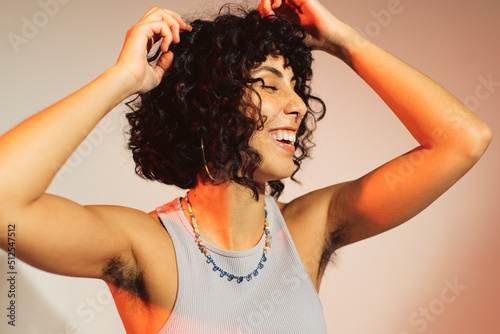 Happy young woman embracing her natural body hair photo