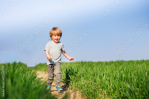 Cute boy run smiling in the clear spring field © Sergey Novikov
