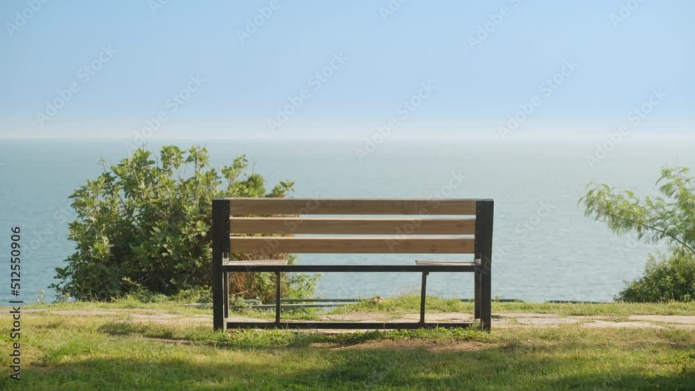 An empty wooden bench on the coast. Sea view. Summer, sunny day, vacation. An empty wooden bench on the coast. Sea view. Summer, sunny day, vacation.