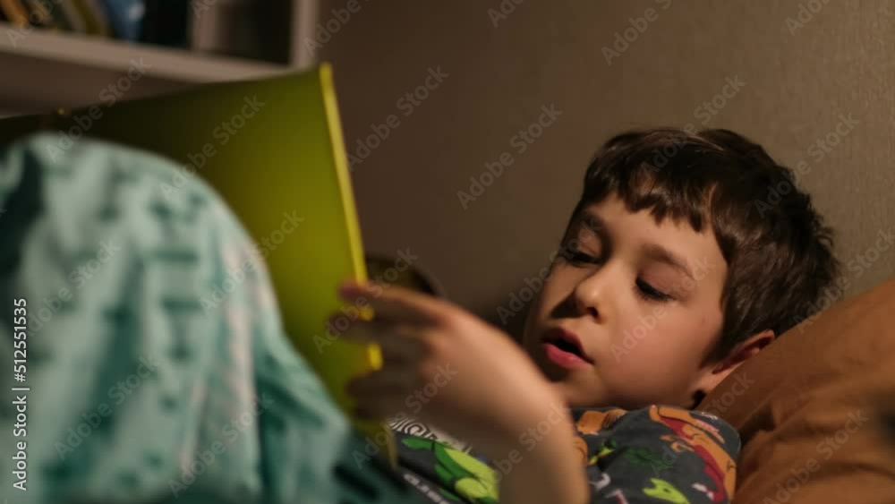 little boy reads a book on his own before going to bed. little boy reads a book on his own before going to bed.