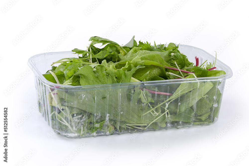 Mix of fresh greens in plastic container on white background Mix of fresh greens in plastic container on white background