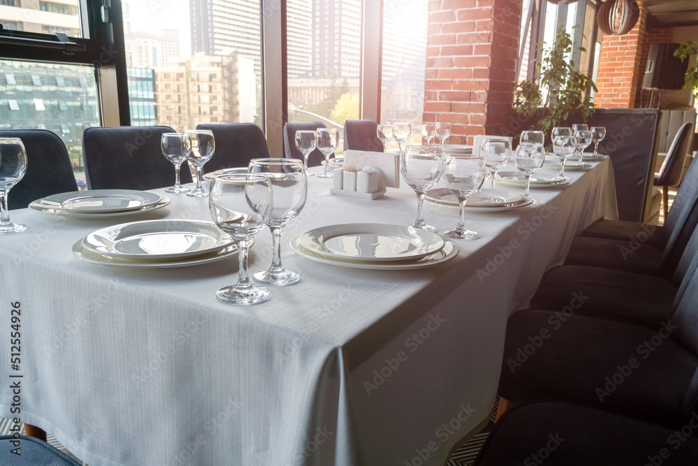 Table set with empty glasses, white plates in a restaurant Table set with empty glasses, white plates in a restaurant