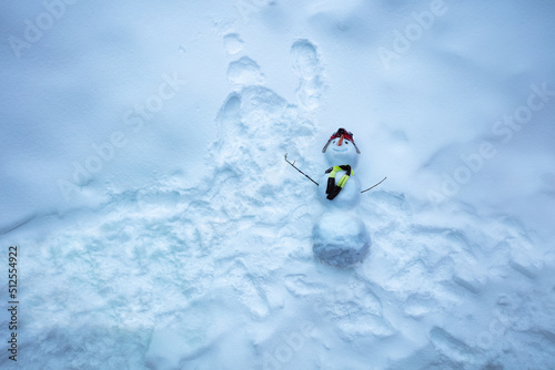 View from top above of snowman with scar hat and carrot nose