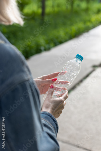 girl carries a transparent water bottle in her hand