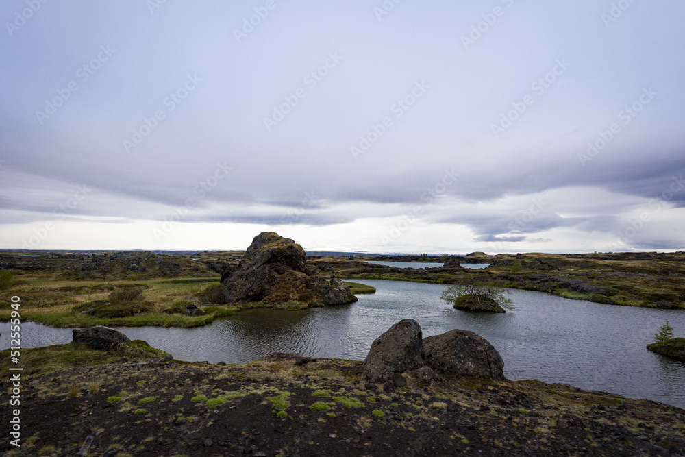 Volcanic rock formations around body of water in Icelandic north