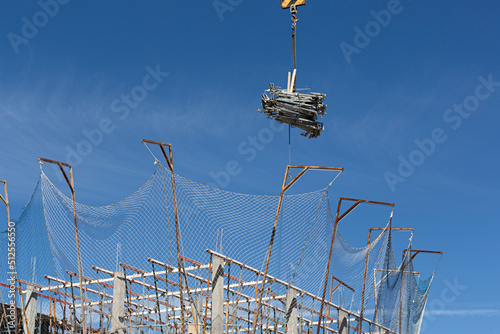 Grúa descargando material de construcción en obra.
