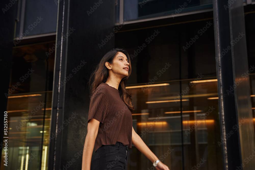 Young businesswoman walking on street smiling