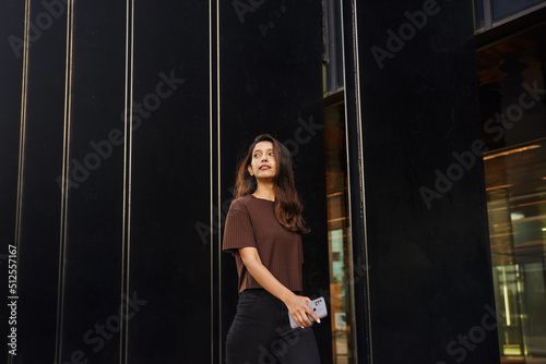 Elegant businesswoman with mobile phone on street