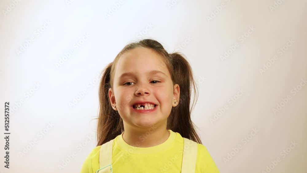 Little funny girl wide smiling with gap in mouth from fallen tooth and diligently showing all teeth closeup, white background. Joyful toothless child. Concept of healthy teeth and beautiful smile. Little funny girl wide smiling with gap in mouth from fallen tooth and diligently showing all teeth closeup, white background. Joyful toothless child. Concept of healthy teeth and beautiful smile.