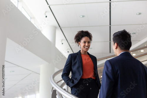 African American businesswoman talking with a colleague on a staircase in an office photo