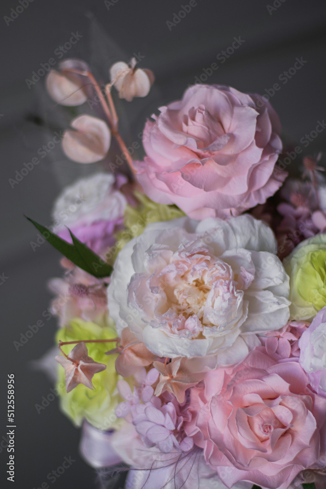 Obraz premium A luxurious bouquet of flowers in a hat box. Composition with pink, white and yellow roses flowers and eucalyptus. Modern Floristry. Woman's day.