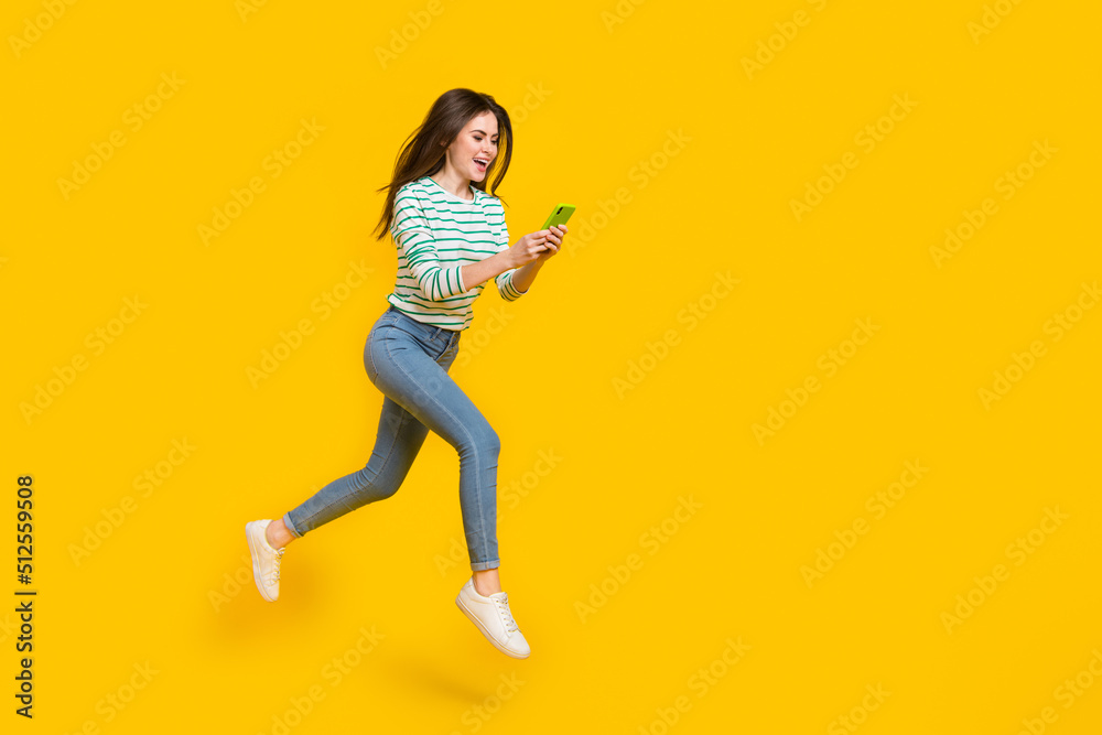 Full body photo of excited cheerful girl influencer chatting with friends write post isolated on yellow color background Full body photo of excited cheerful girl influencer chatting with friends write post isolated on yellow color background