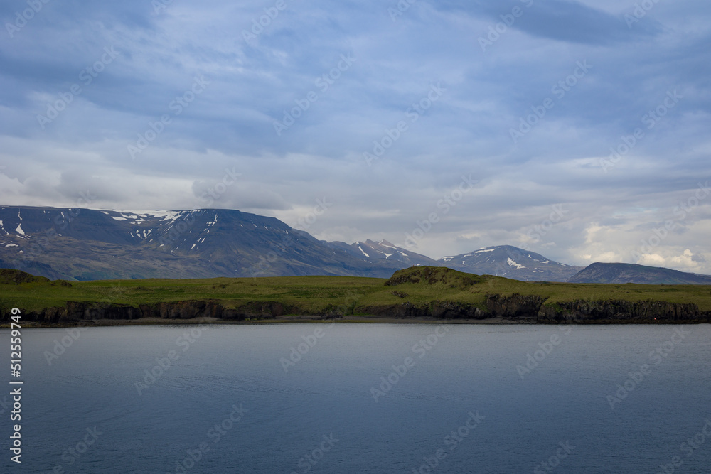 Icelandic Atlantic coastline with pattern of moss covered hills and majestic mountains Icelandic Atlantic coastline with pattern of moss covered hills and majestic mountains