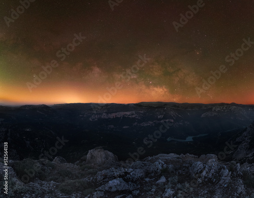 Milky Way core rising horizontally on horizon from mountain edge and above a grand valley
