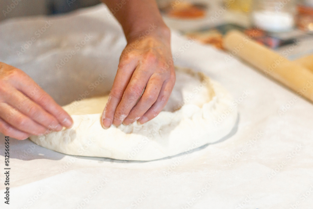 Women's hands sculpt from the dough a large pirok with potatoes and msyaom. Home national cuisine Women's hands sculpt from the dough a large pirok with potatoes and msyaom. Home national cuisine