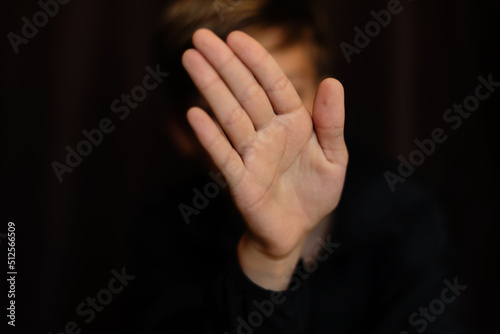 Portrait of blonde teenage boy on dark background indoor. Low key close up shot of a young teen boy, adolescence. Selective focus. Loneliness, sadness, adolescent anxiety, emotional © Rodica