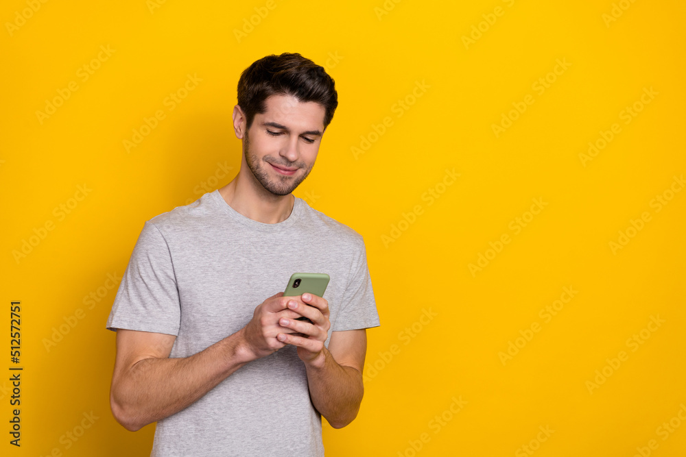 Photo of nice brunet young guy look telephone wear trend cloth isolated on yellow color background Photo of nice brunet young guy look telephone wear trend cloth isolated on yellow color background