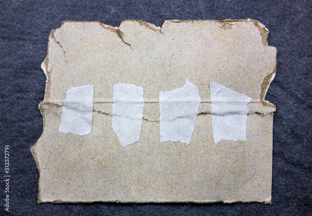 Two pieces of old torn cardboard are glued together with white paper ...