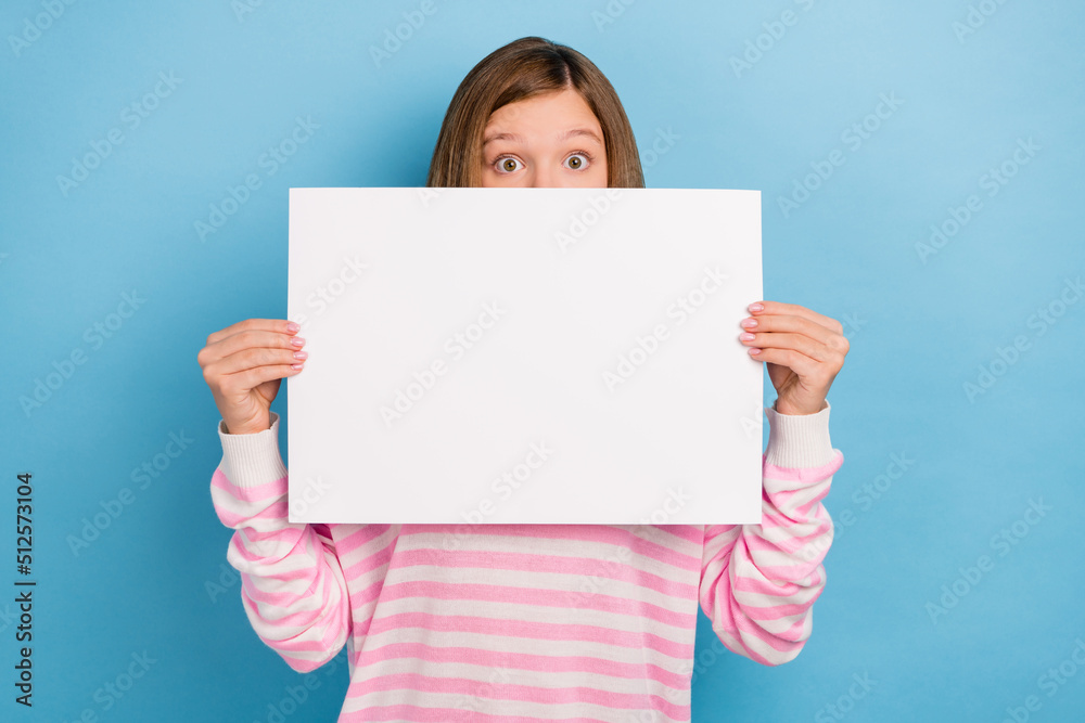 Portrait of young girl hold empty space banner cover mouth face look camera isolated on blue color background Portrait of young girl hold empty space banner cover mouth face look camera isolated on blue color background