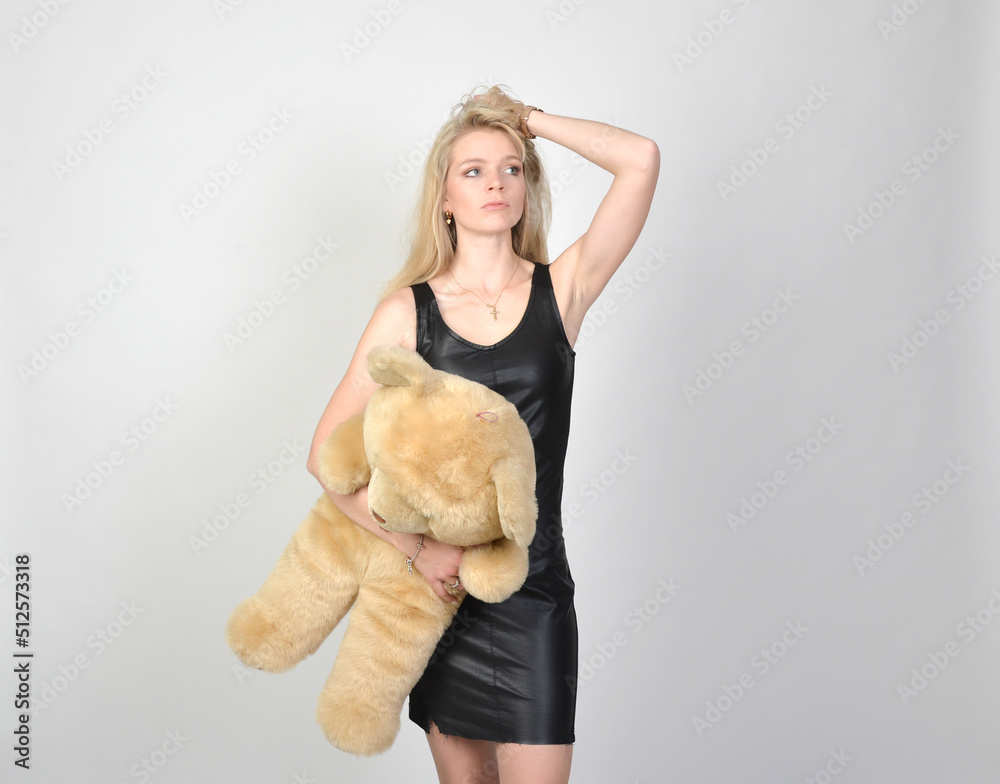 junge große tall schlanke frau lange beine blonde haare frisur dünn kleid spielt mit teddy sugardaddy