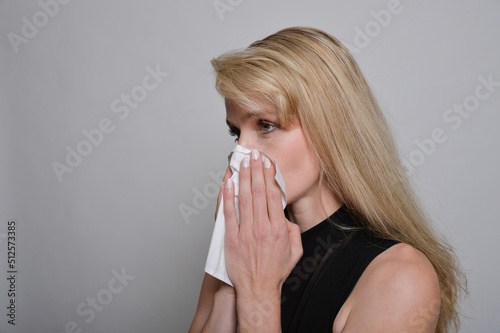 junge hübsche frau erkältung grippe niessend niesen heushnupfen mit taschentuch niesend nießen schnaubend photo