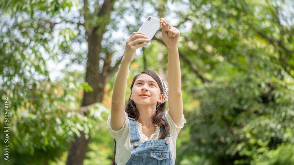 Thoughtful smile woman in park using smart phone for selfie photo , Portrait of a young charming business woman checking online Business work on her smart phone outdoors in the park Thoughtful smile woman in park using smart phone for selfie photo , Portrait of a young charming business woman checking online Business work on her smart phone outdoors in the park